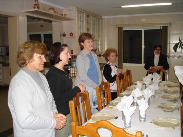 there are people standing around the table with white plates