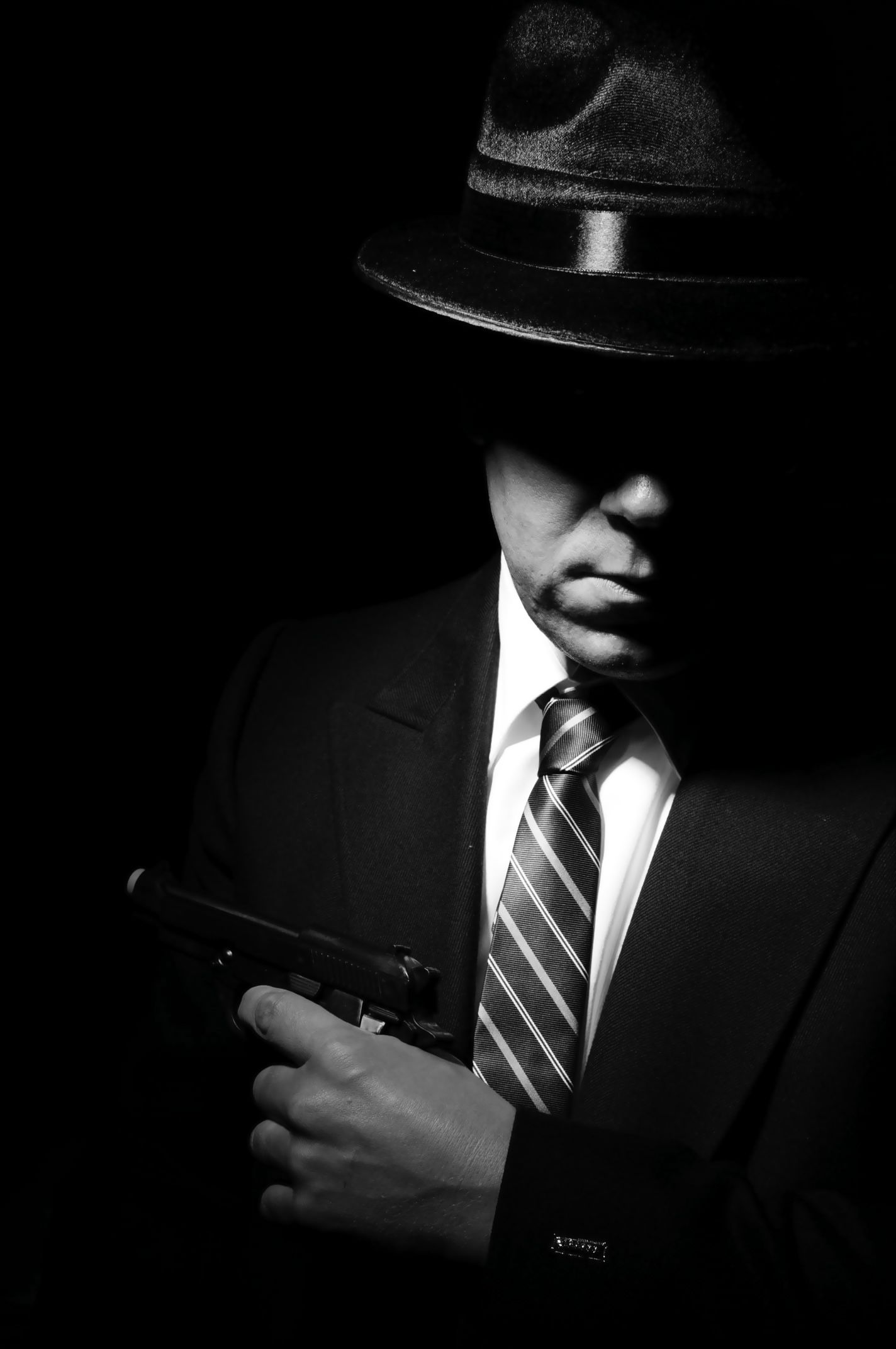 a man in a suit and tie holds a gun