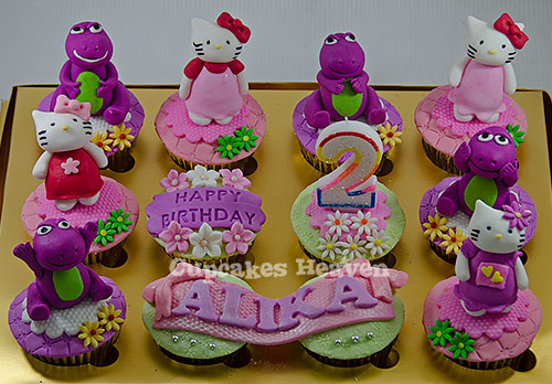 a tray of cupcakes with various design items