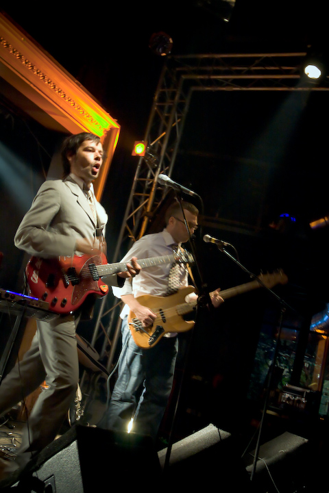 two musicians on stage performing at night