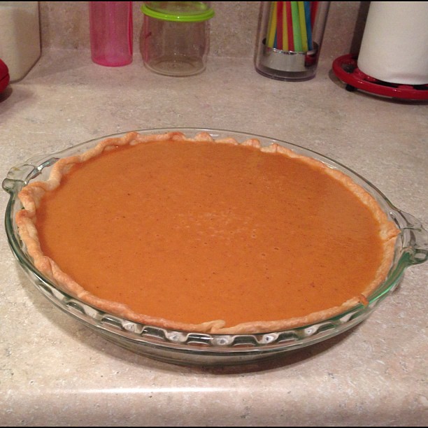 a pie dish sitting on a counter in front of many utensils