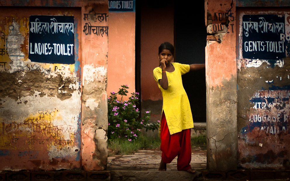 a woman in a yellow and red top points a finger