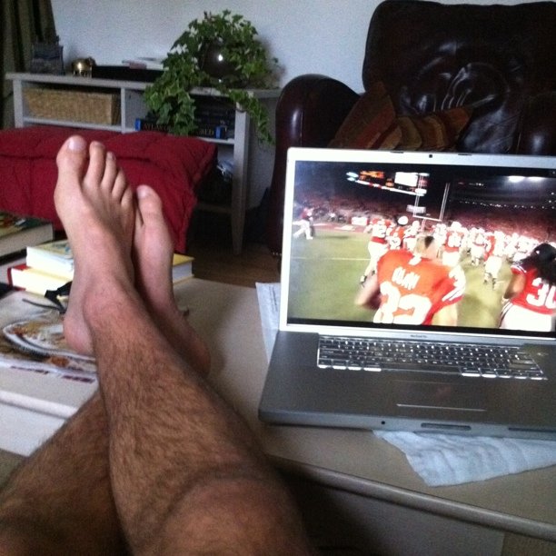 a man is watching football on his laptop