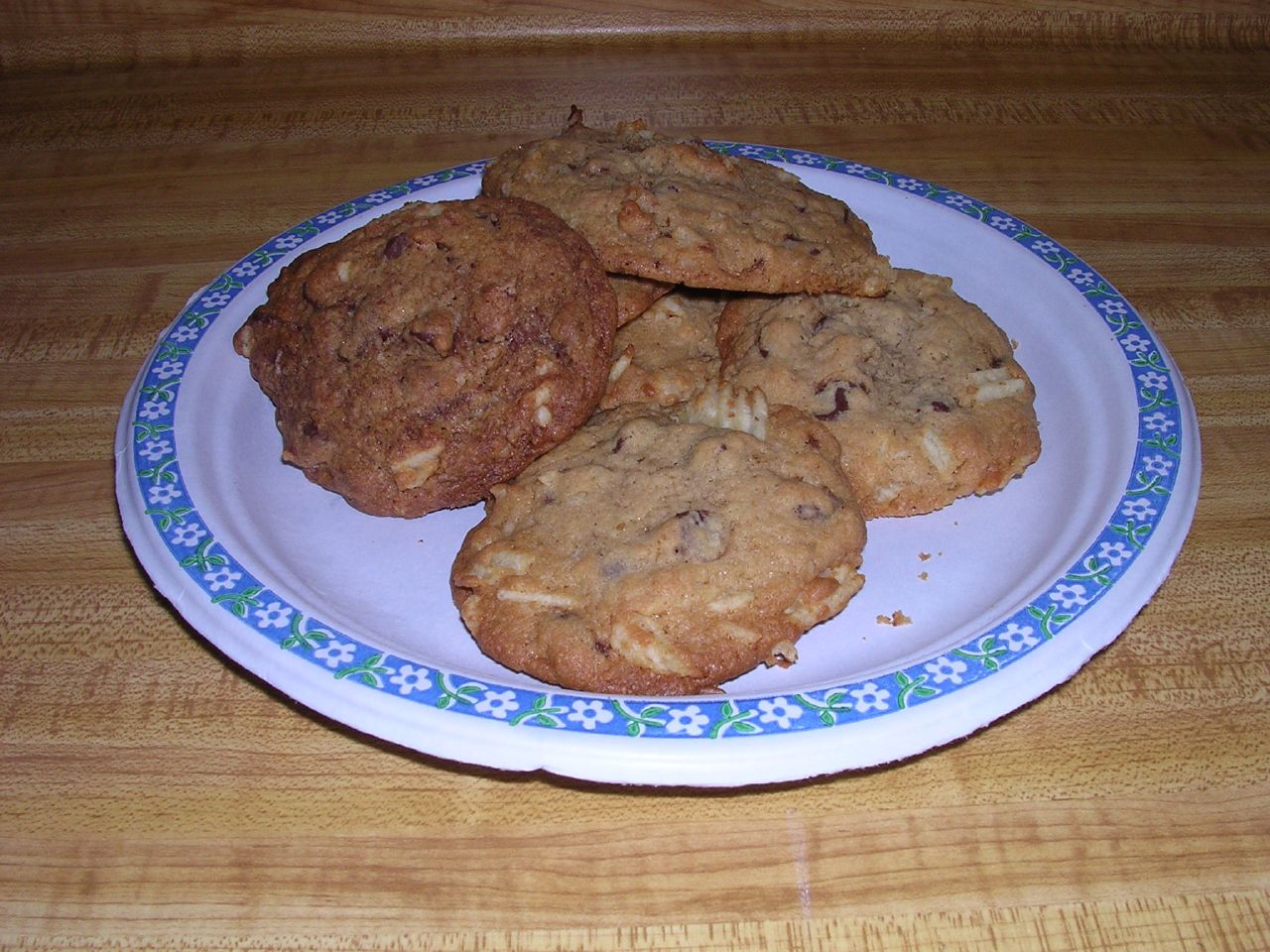 three chocolate chip cookies on a plate with blue trim