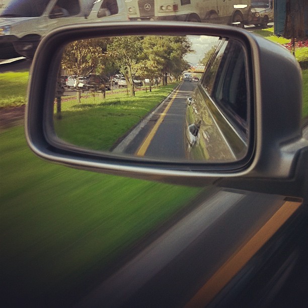 a reflection of a rear view mirror and a road