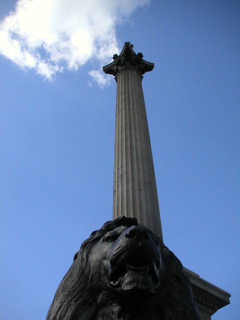 a statue on the ground in front of a large pillar