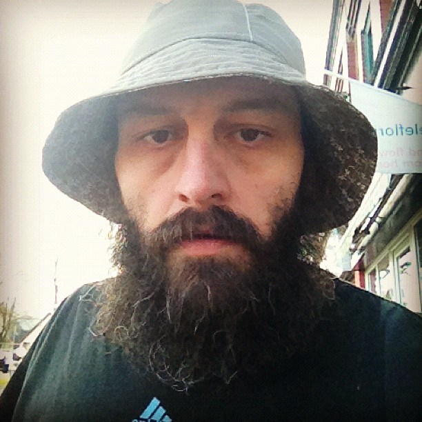 a man with long beard wearing a hat