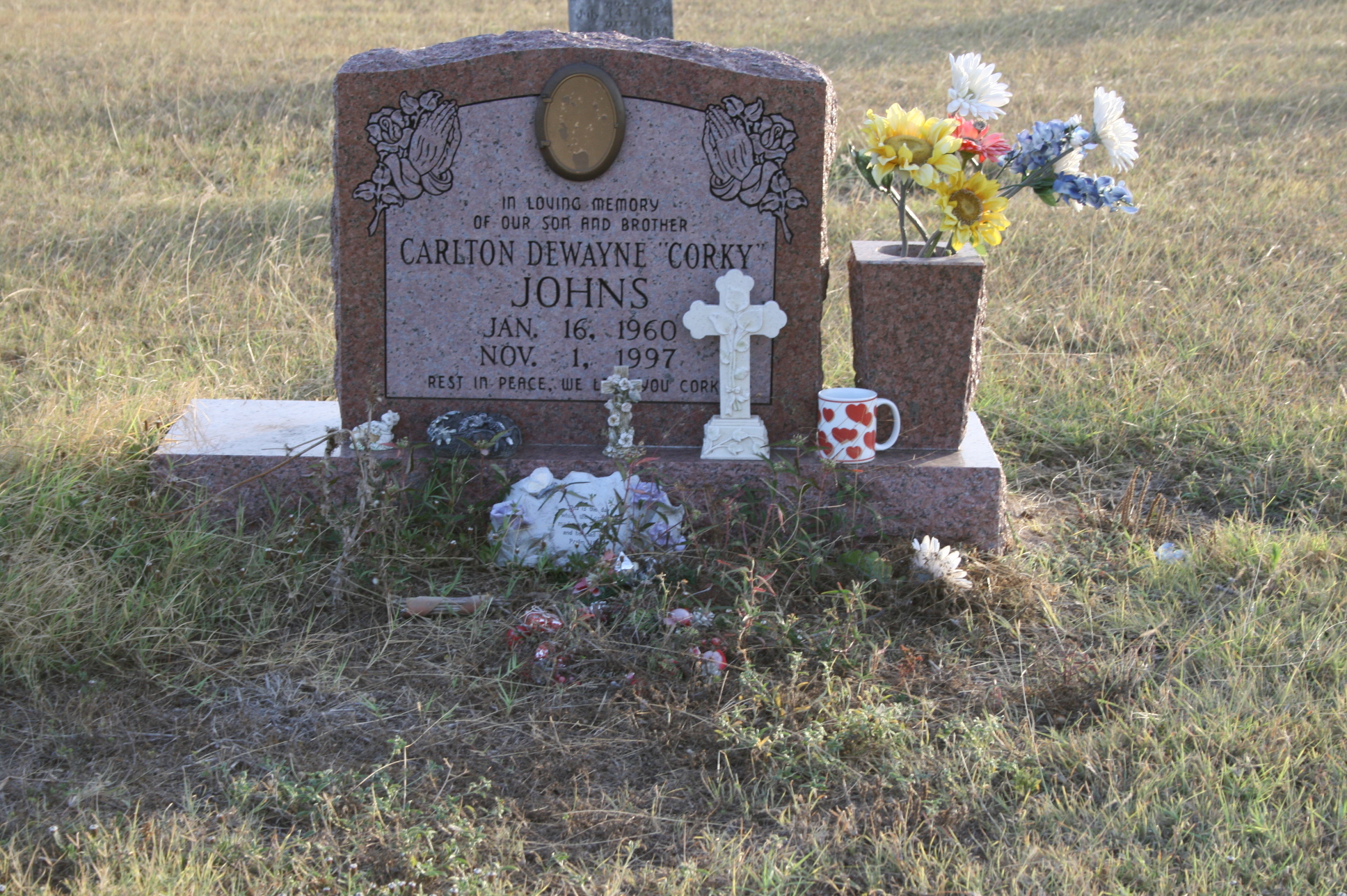 a grave in a grass field with flowers