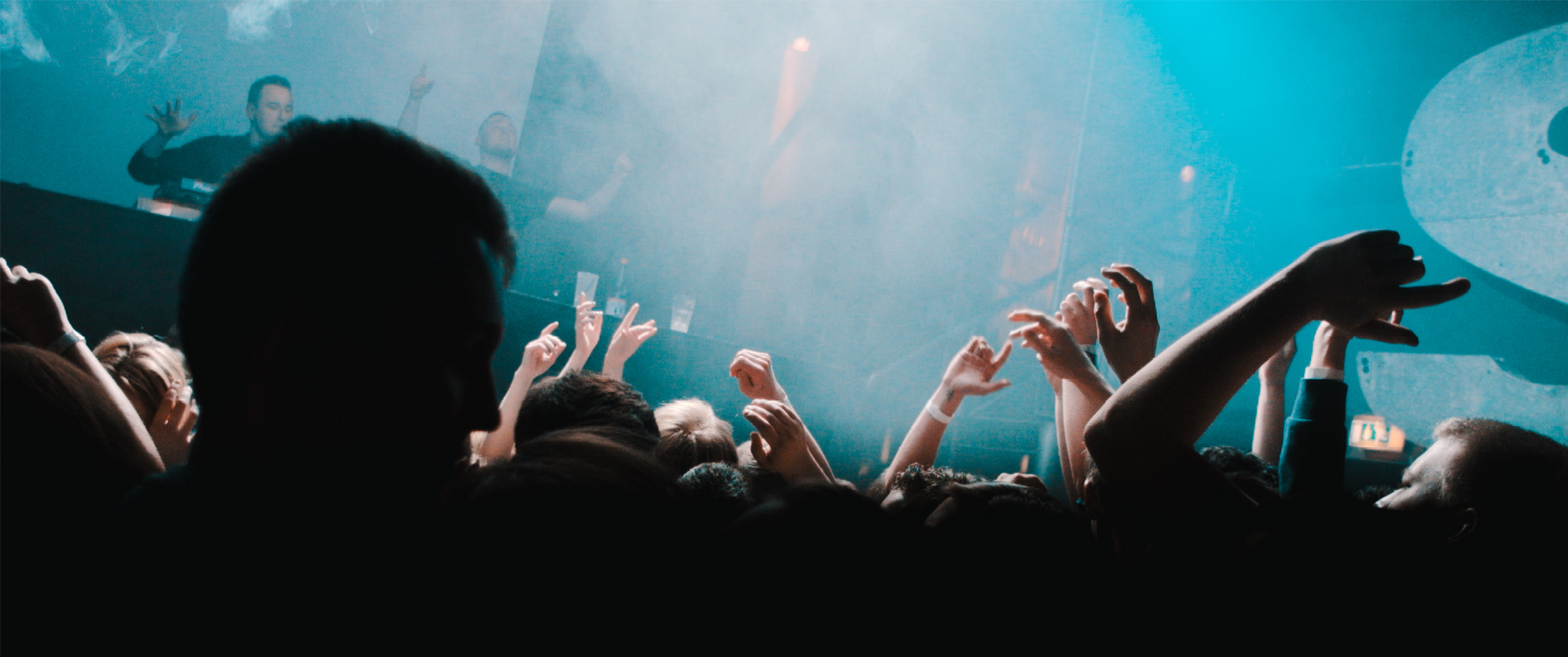 a large crowd is clapping and some people in the background are reaching out