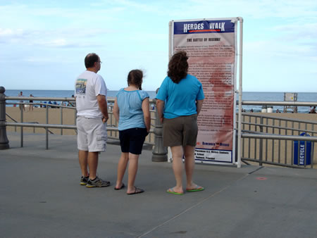 people standing in front of a poster on the beach