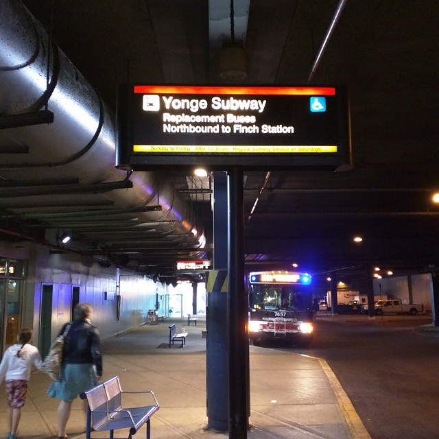 a bus is waiting at the front of a subway terminal