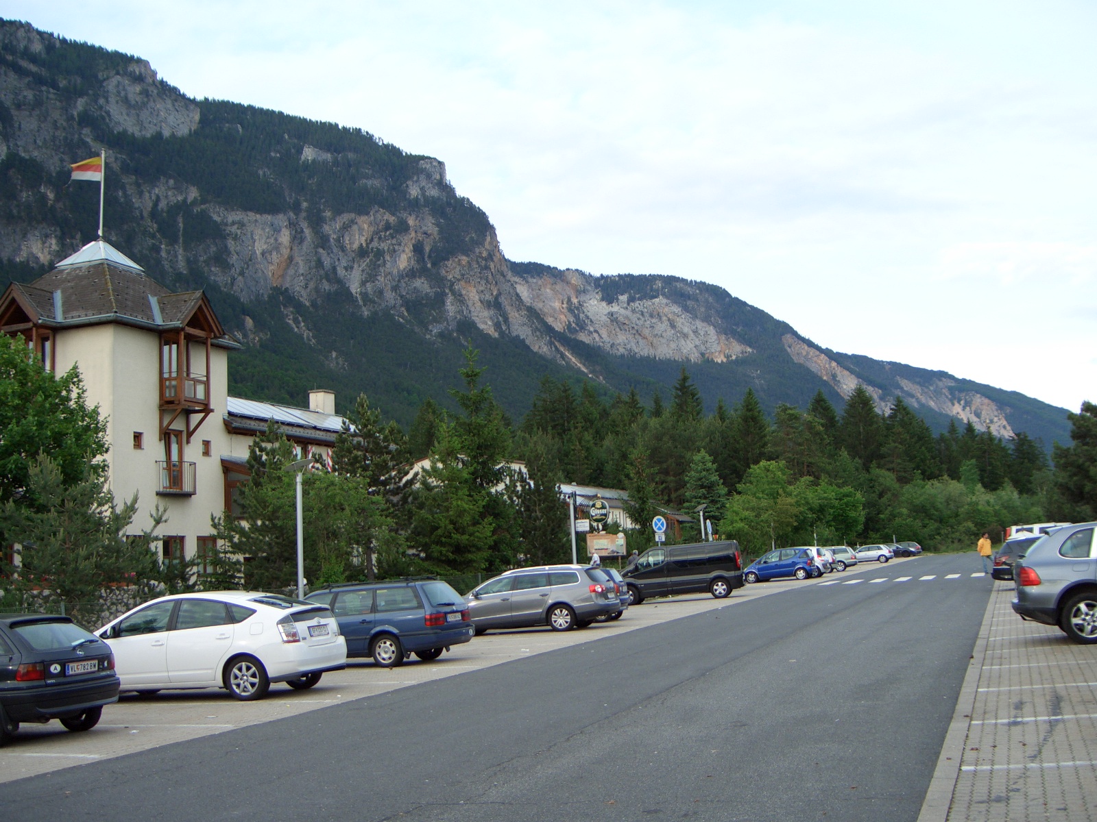 cars parked on the side of the road with mountains in the background