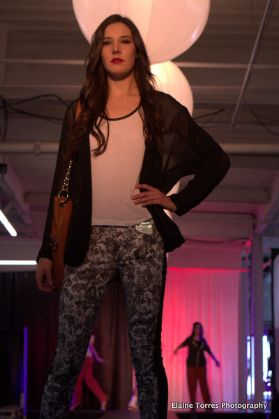 a woman in white shirt standing on top of a runway