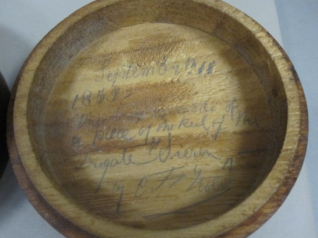 two antique wooden bowls are on display with handwriting on the sides