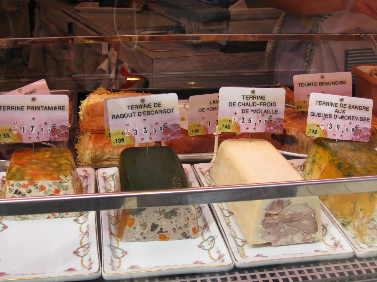 several different types of cheeses on display in glass