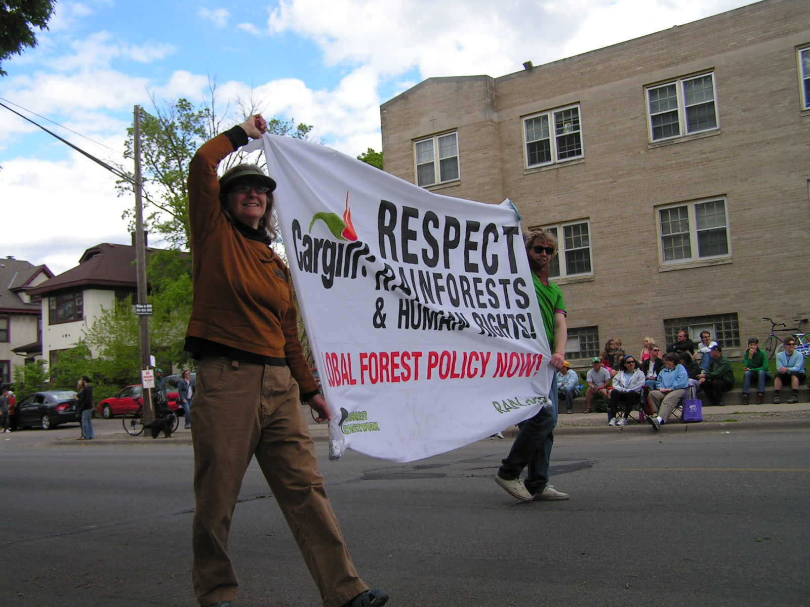 a man holding up a large sign while walking on the street