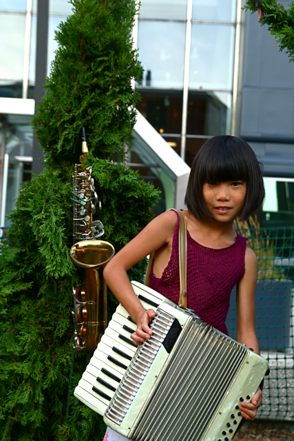 a young woman holding a musical instrument outside