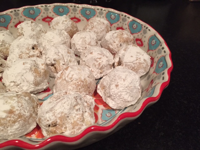 a bowl filled with powdered donuts on top of a counter
