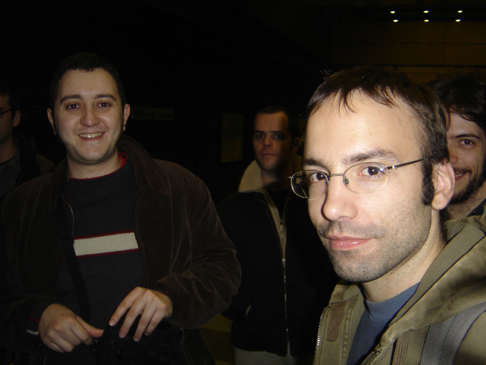 a man with glasses and another man looking at the camera