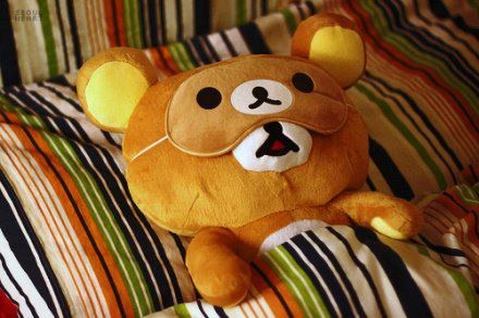 a teddy bear on a bed with lots of pillows