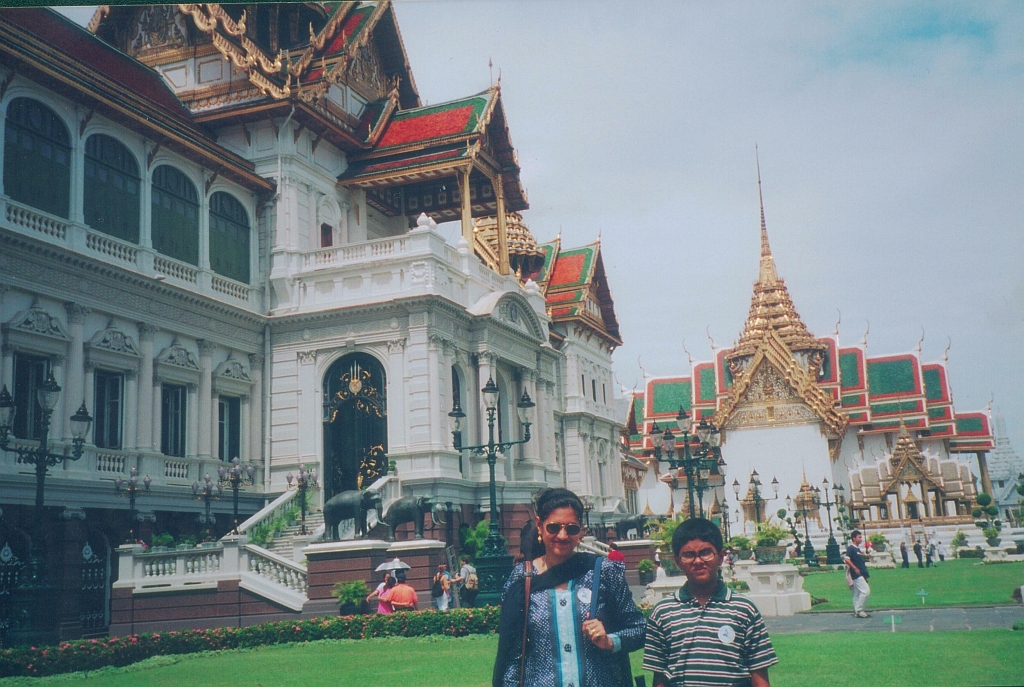 two people standing in front of the building with many spires