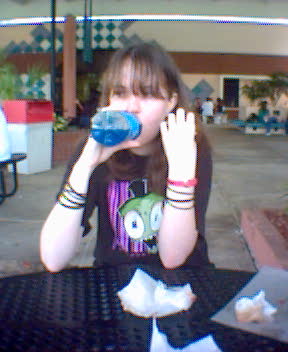 a woman drinking from a blue water bottle