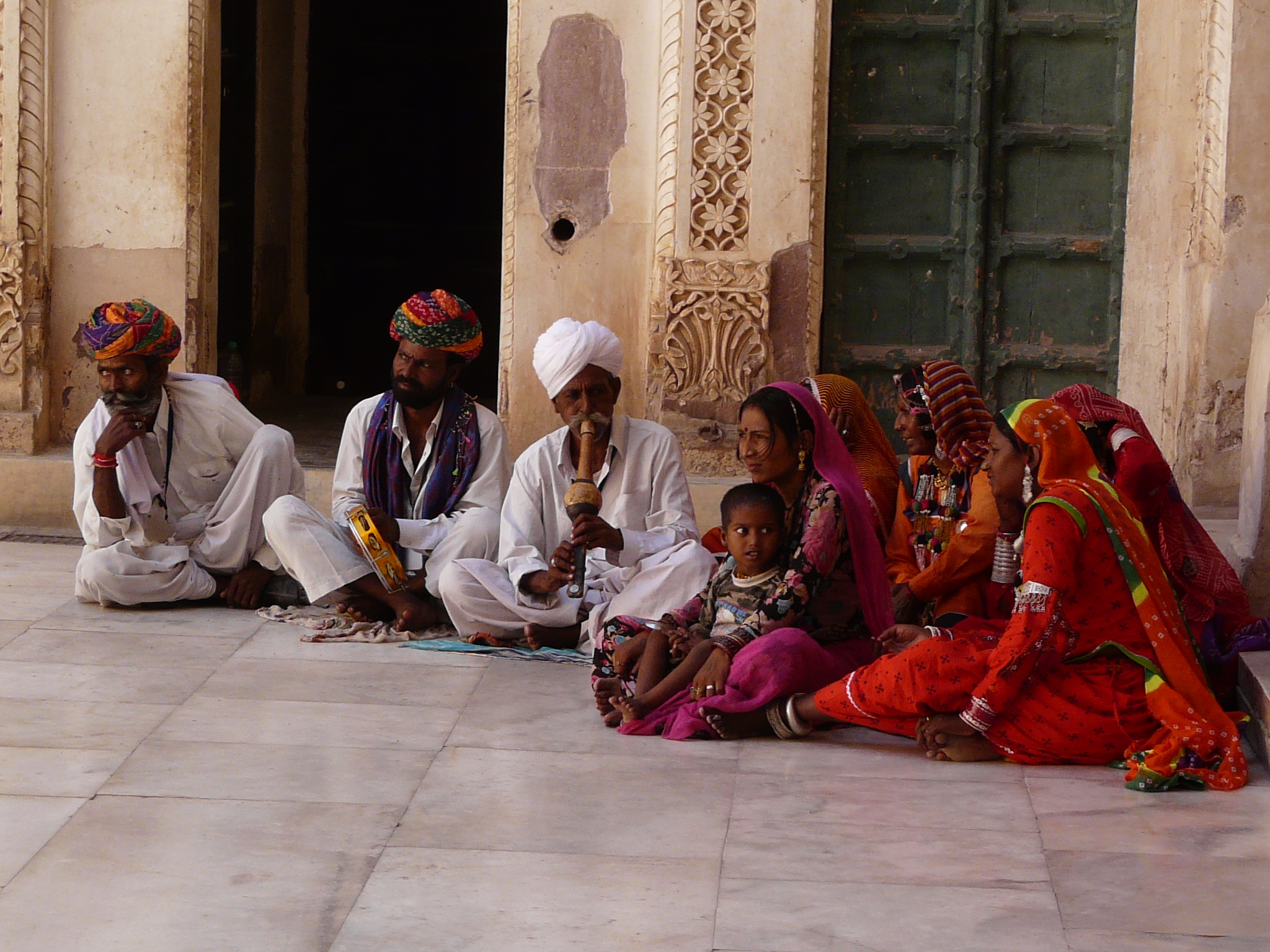 five people are sitting on the ground in a row