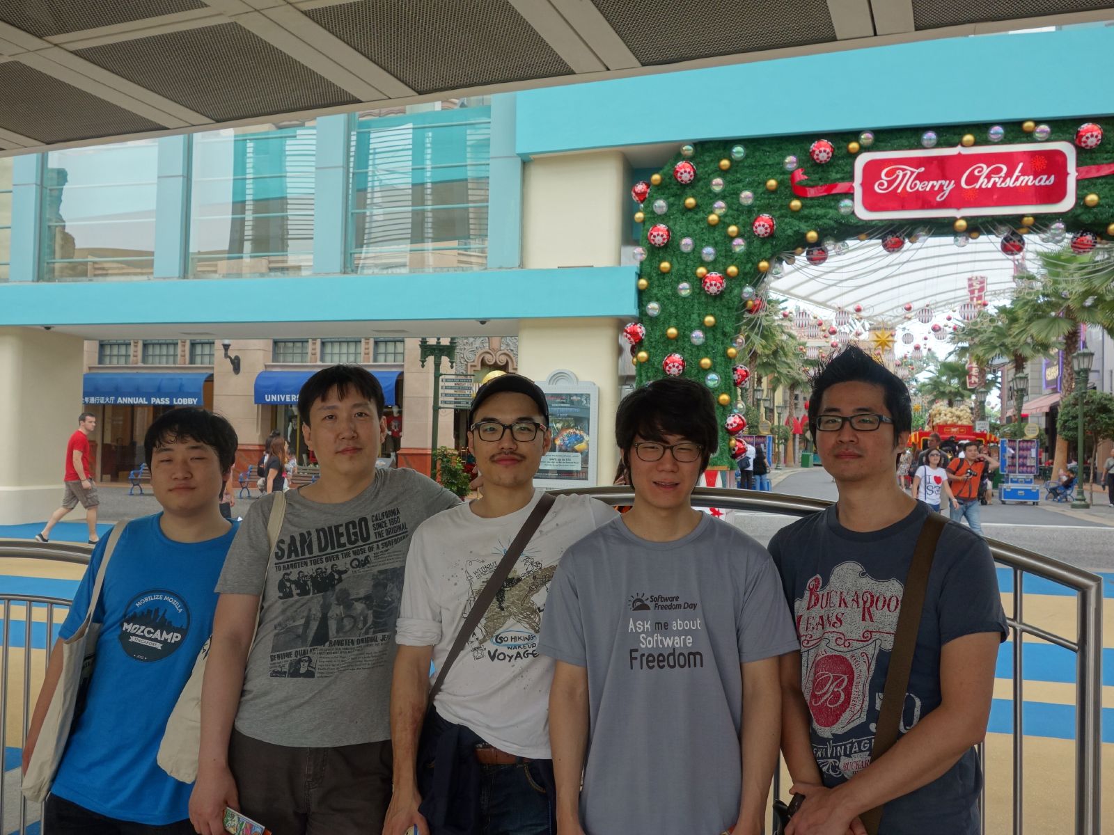 group of four men posing together in front of a store