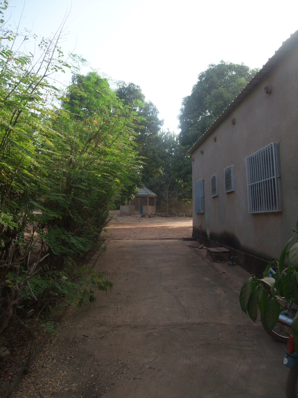 a street in front of a small building with a big door