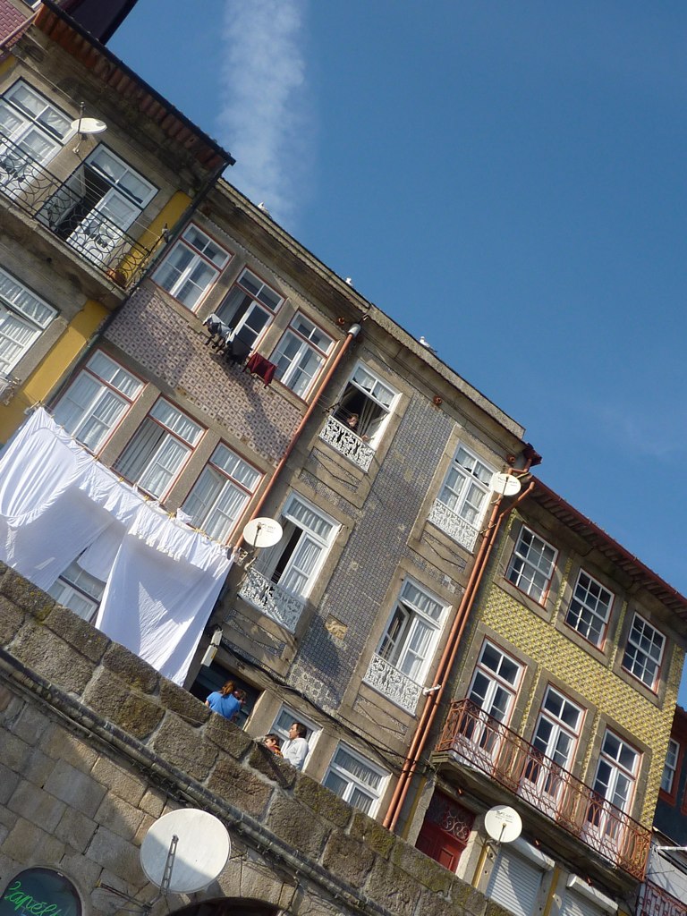 several buildings with white balconies in the windows and clothes hanging on a line