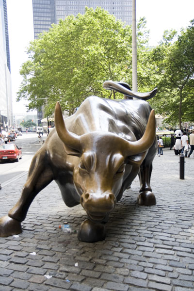 the bronze bull statue on the sidewalk has big horns