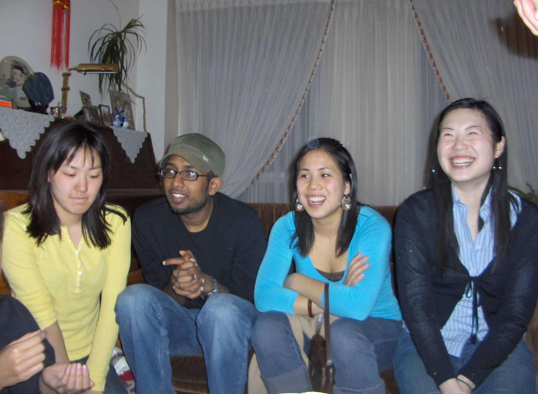 four smiling people on a couch with a ds in the background