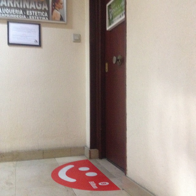 a doorway with a red and white mat in between the doors