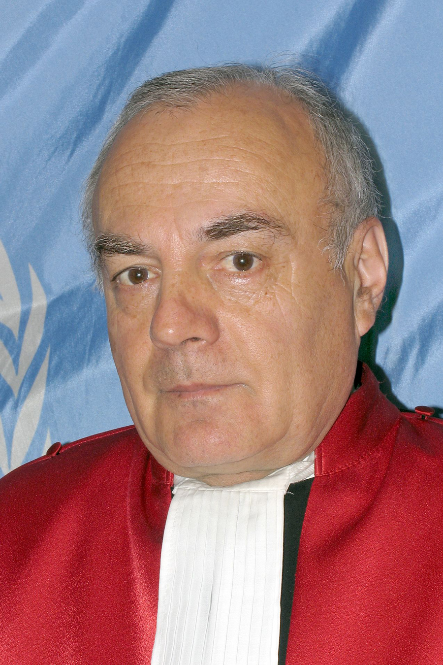 a man in a red robe with a red coat and black shirt