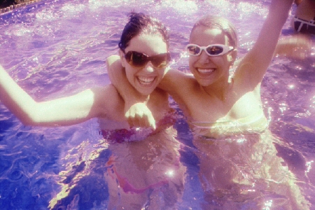 two women are posing in the pool for a picture