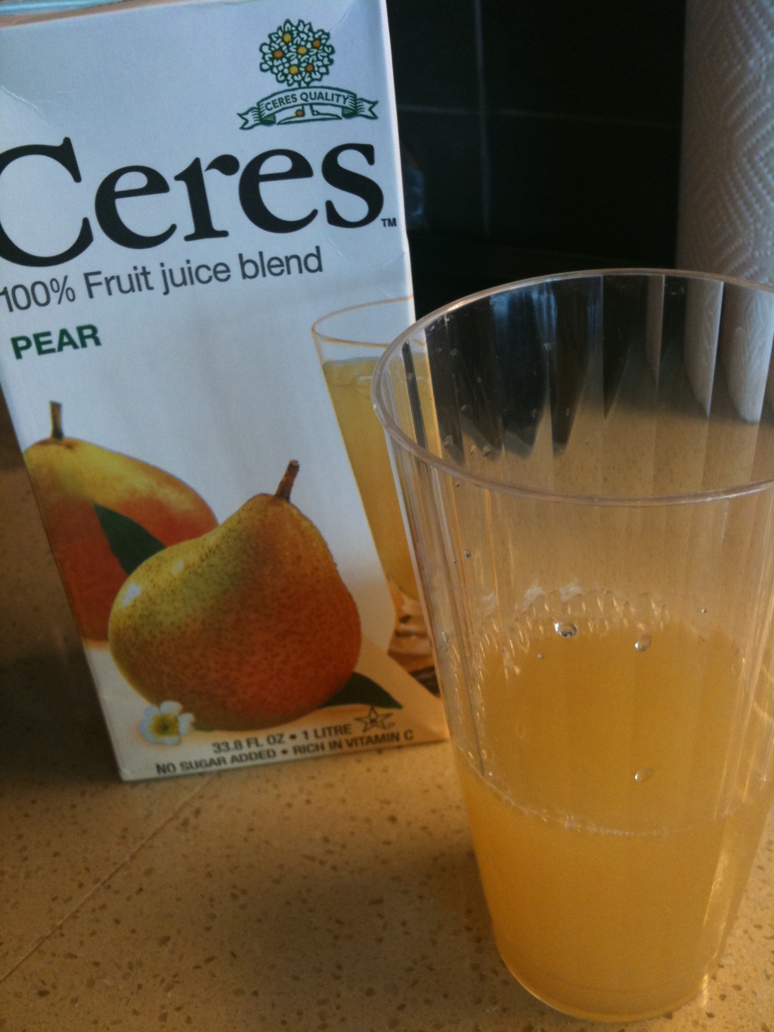 a glass with juice in it next to a carton of ceres fruit juice