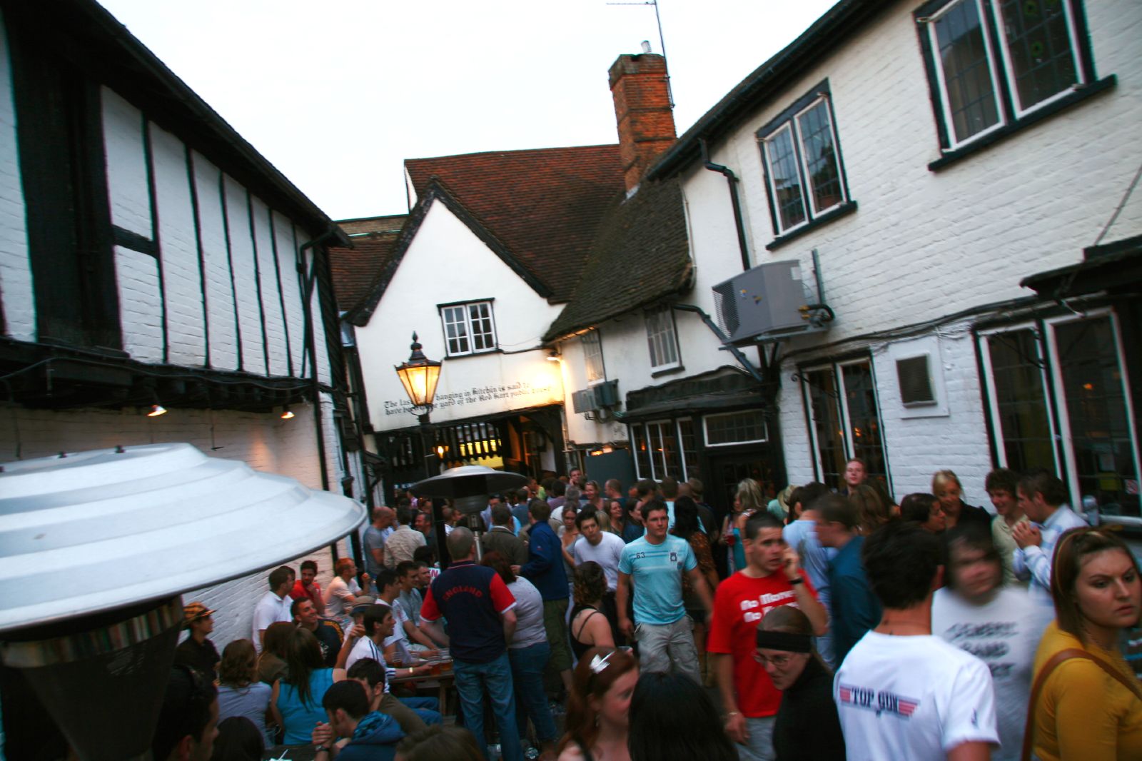 crowd of people outside a pub on a street