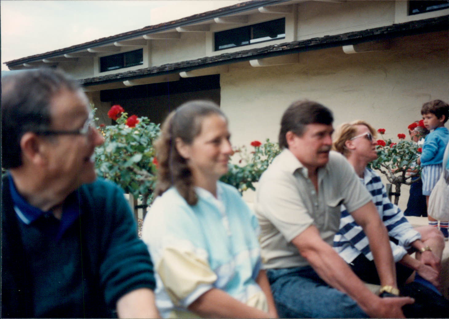 a bunch of people are sitting outside with flowers