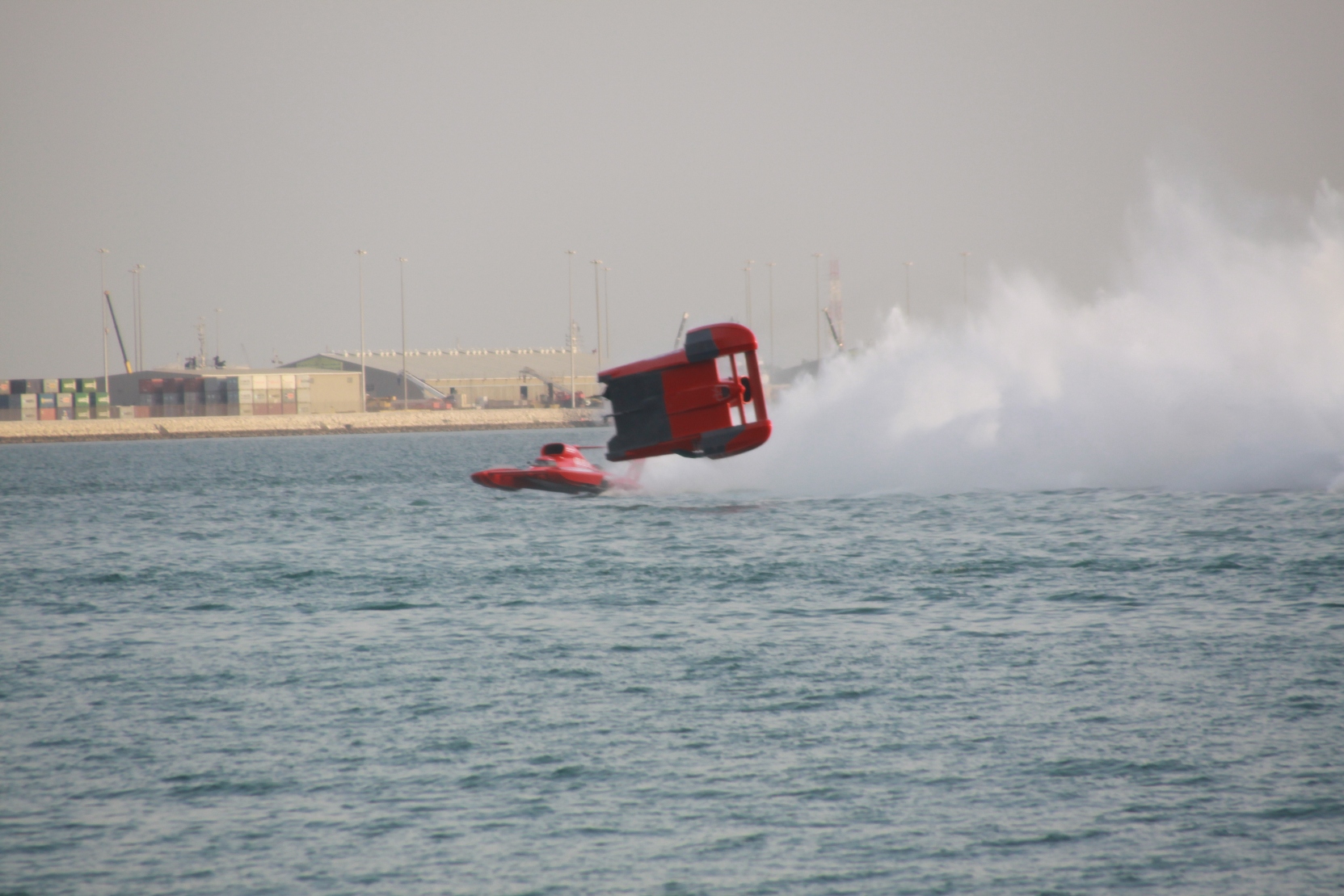 a red and black jet is above a wakeboard