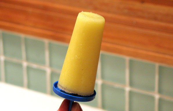 a yellow tube in someone's hand above a faucet