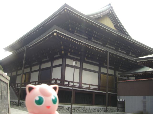 a very tall pretty building with an ugly pink pig next to it