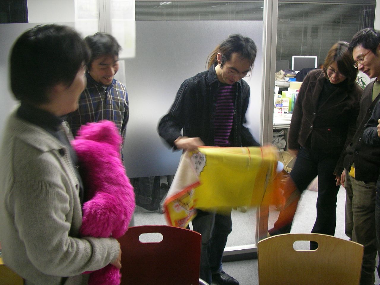 five young adults are playing with stuffed animals