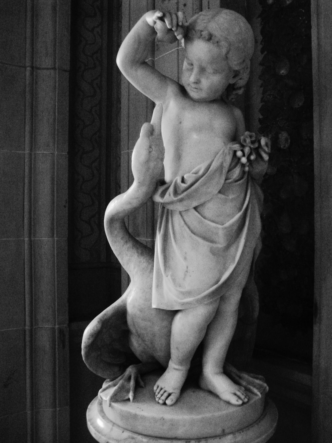 black and white pograph of a cherub statue holding the baby