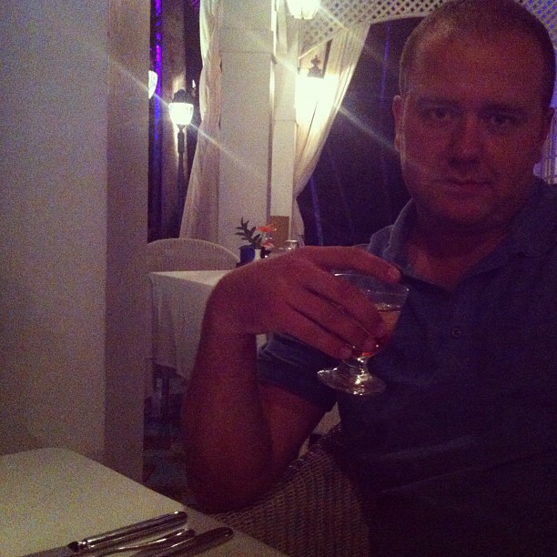 a man holding a wine glass and staring ahead