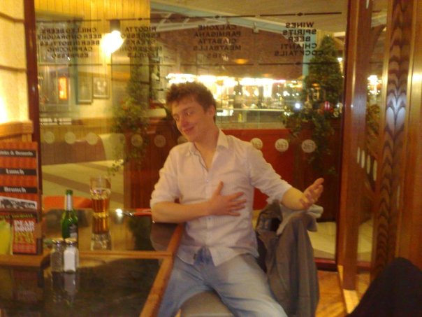 a man is sitting down in the window sill of a restaurant