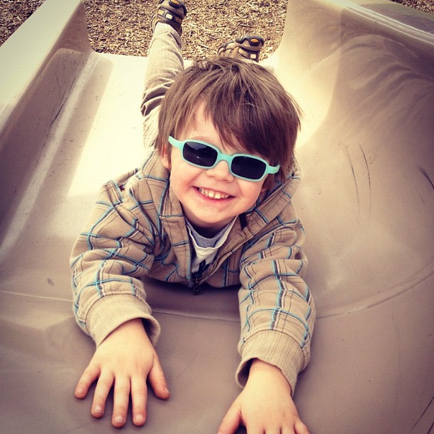 a  with sunglasses plays on a slide