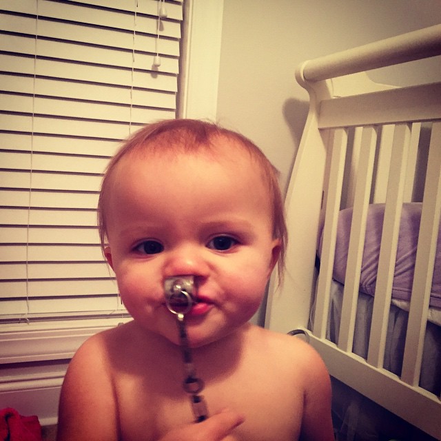 a small child with a pacifier in their mouth