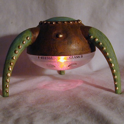 a small light up object sitting on top of a bed