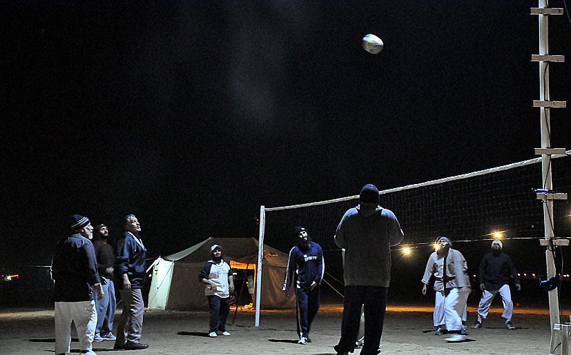 several young men are playing volleyball together at night