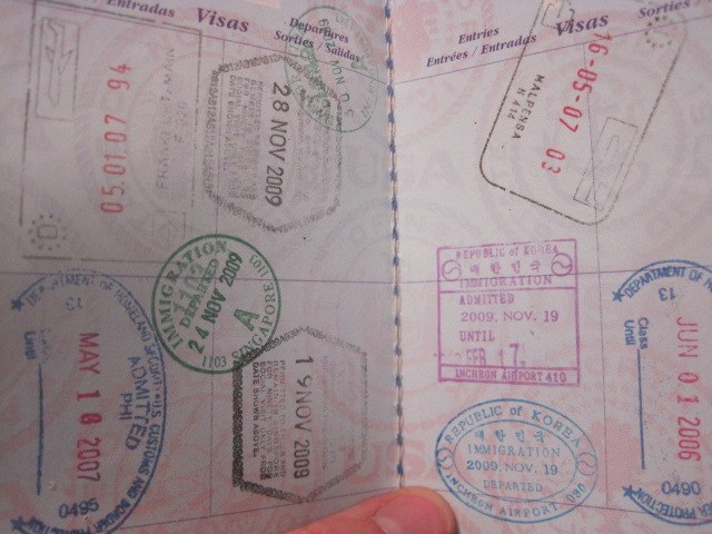 a person holds out an unused passport with visa stamps on it